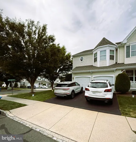 a car parked in front of a house with a yard