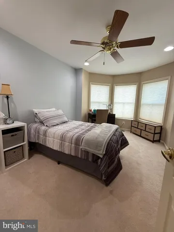 a bedroom with a bed and a flat tv screen on dresser