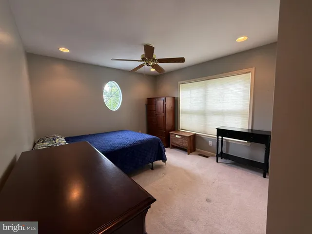 a bedroom with a bed and a ceiling fan