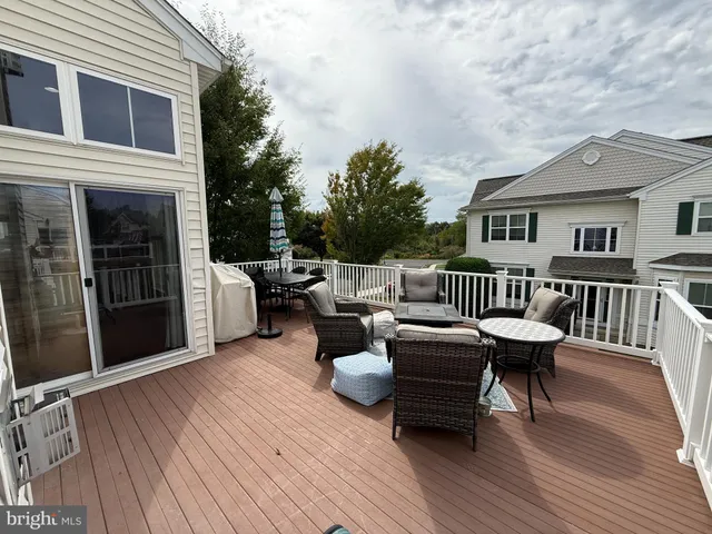 a balcony with couches and a potted plant on a table