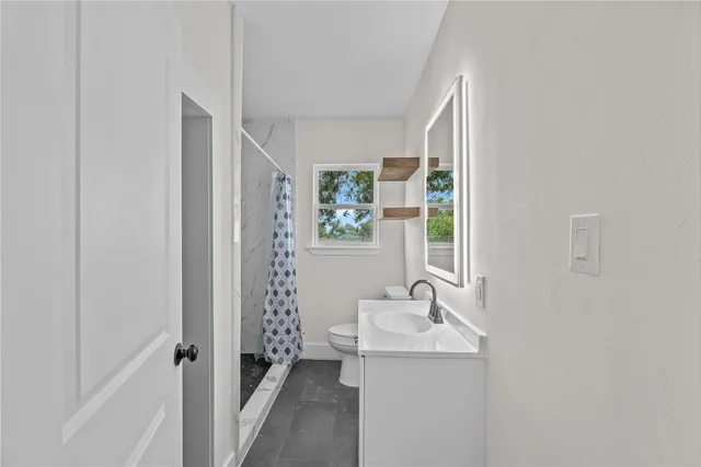 a bathroom with sink a mirror a window and vanity