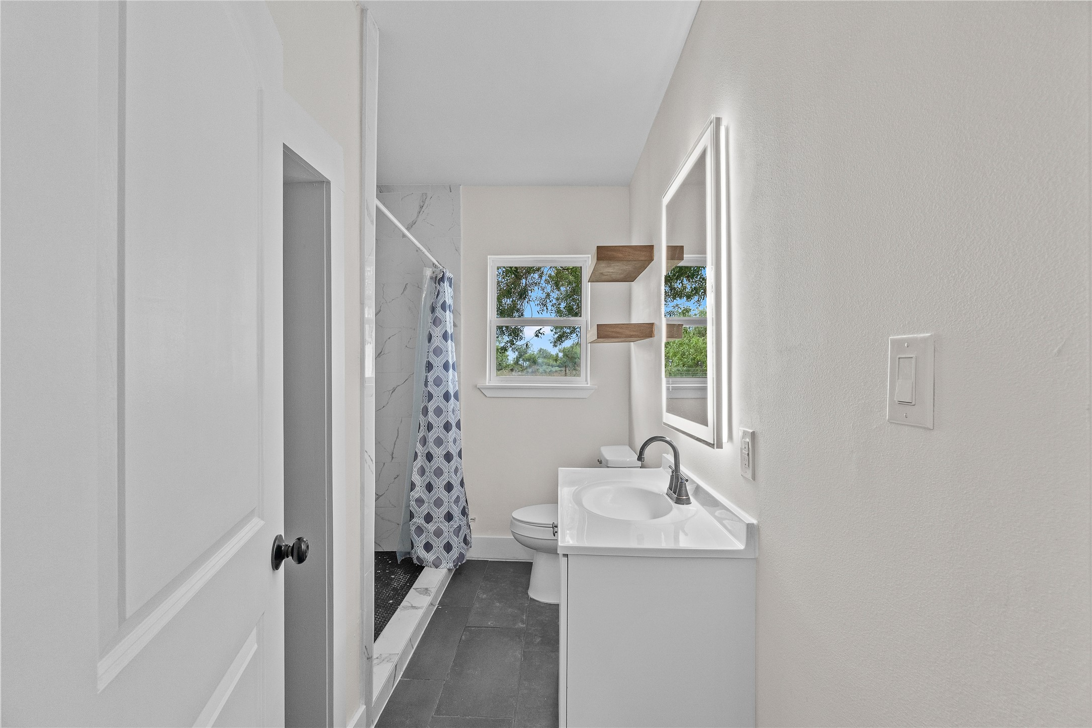16752 Rio Rancho Road Harlingen, TX 78552 - Photo 12 of 25 a bathroom with sink a mirror a window and vanity
