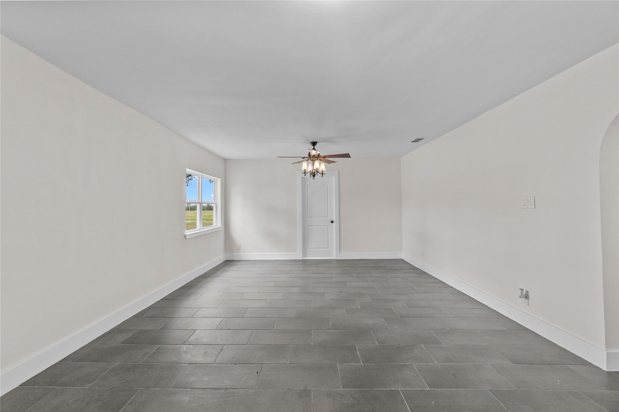 16752 Rio Rancho Road Harlingen, TX 78552 - Photo 4 of 25 an empty room with a windows and a ceiling fan