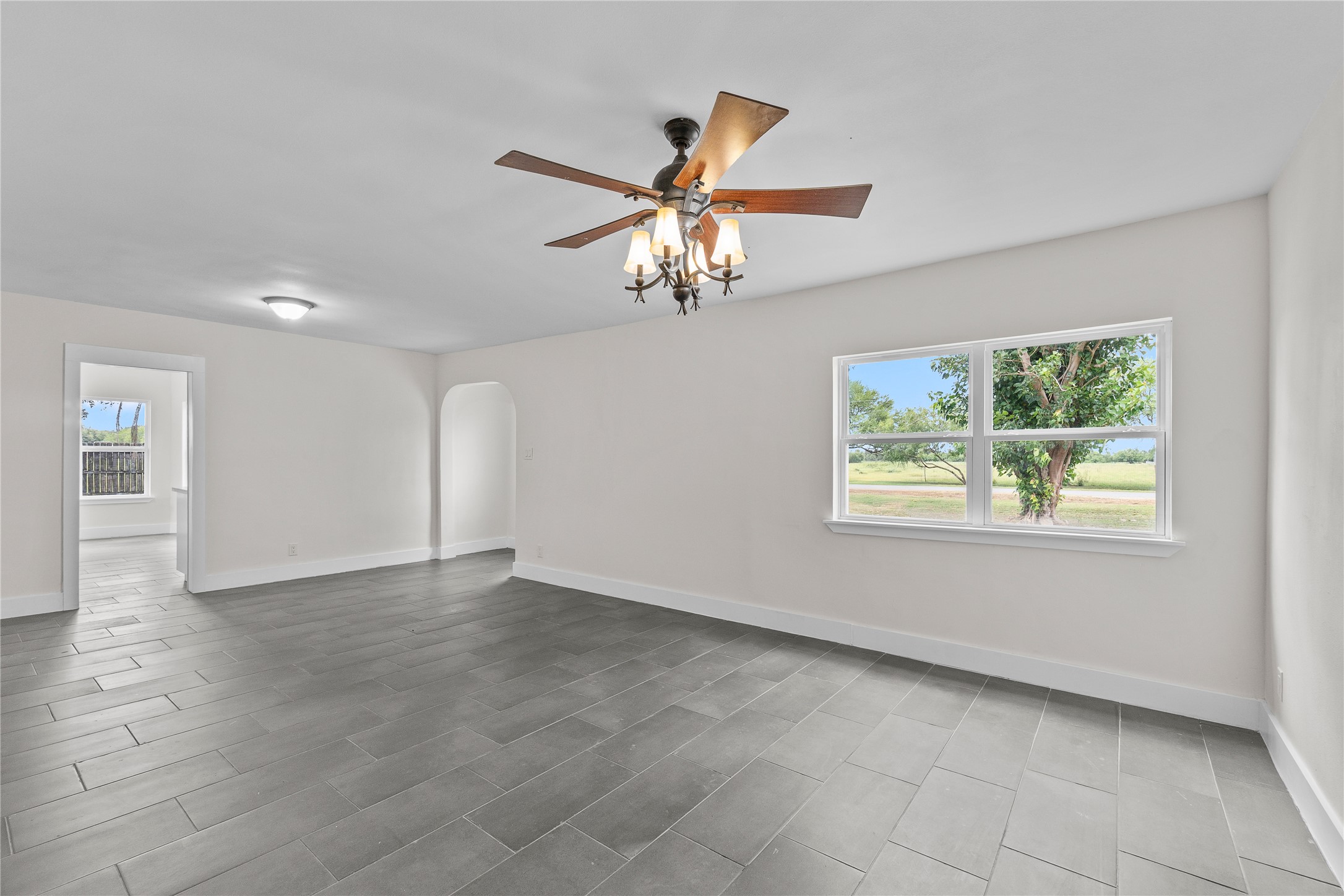 16752 Rio Rancho Road Harlingen, TX 78552 - Photo 6 of 25 a view of an empty room with window and chandelier fan