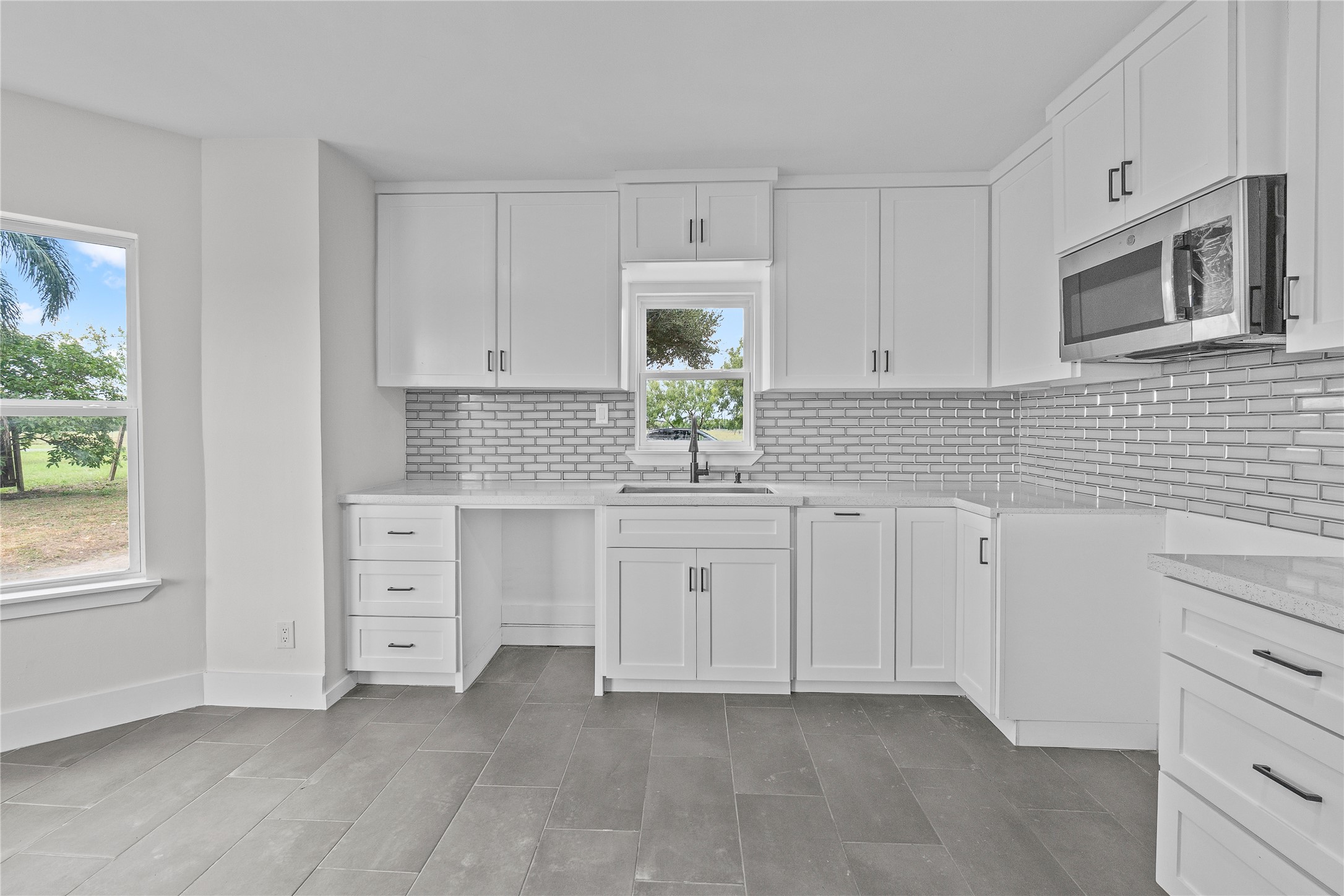 16752 Rio Rancho Road Harlingen, TX 78552 - Photo 7 of 25 a kitchen with white cabinets and window