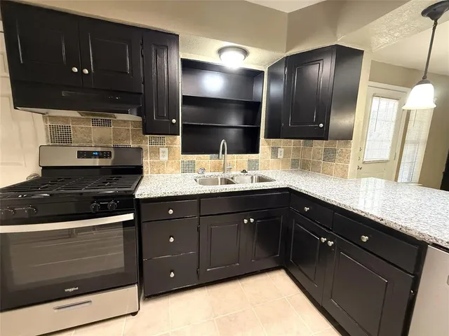 a kitchen with a sink stove and cabinets