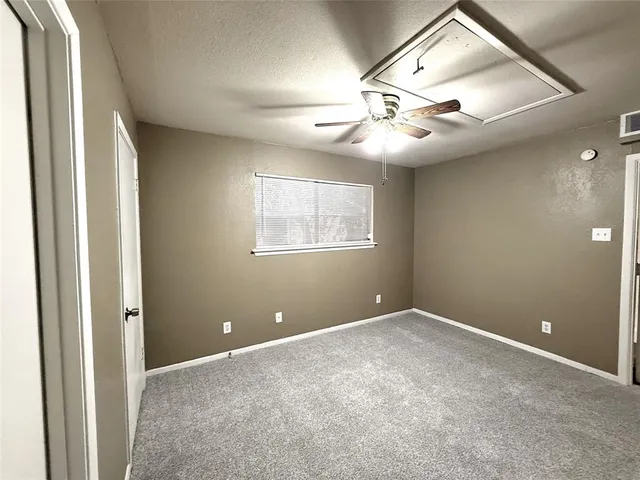 an empty room with windows and fan