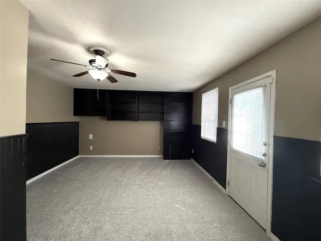 a view of empty room with a kitchen