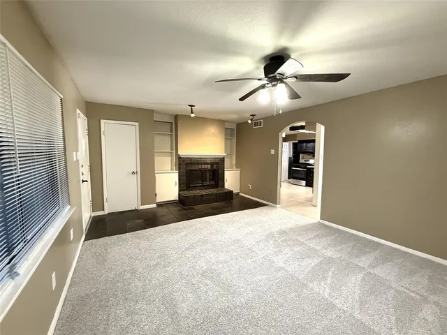 a view of empty room with a fireplace and fan