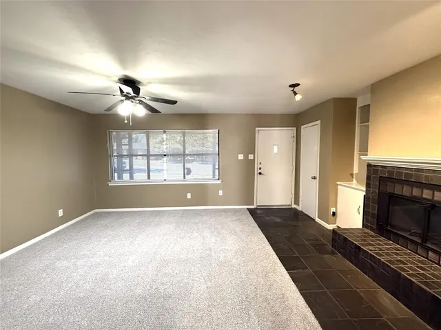 a view of an empty room with a fireplace and a window