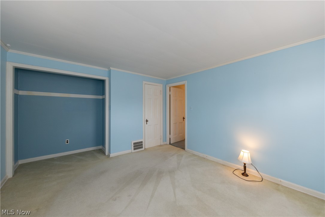 1050 Renfield Road Cleveland Heights, OH 44121 - Photo 31 of 41 Unfurnished bedroom featuring light colored carpet, ornamental molding, and a closet