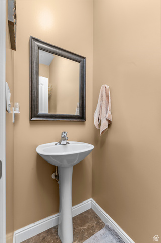 5702 950 North Ogden, UT 84404 - Photo 20 of 36 Pedestal sink with chrome faucet, framed mirror, and warm beige wall tones