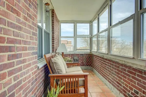 a view of a balcony with wooden floor and furniture
