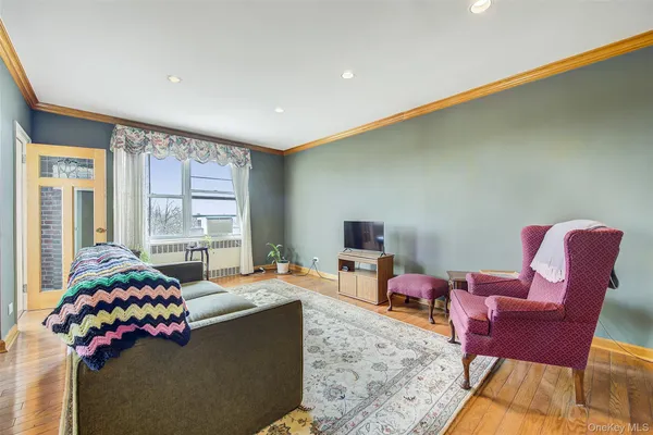 a living room with furniture a flat screen tv and a large window