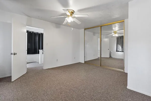 a bedroom with a bed and dresser with mirror