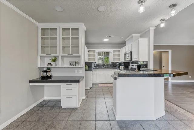 a kitchen with granite countertop a sink and cabinets