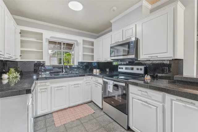 a kitchen with stainless steel appliances granite countertop a sink and cabinets