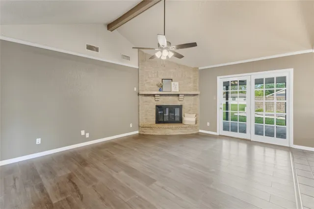 an empty room with windows and fireplace