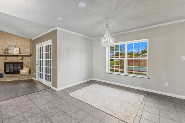 a view of an empty room with a window and fireplace