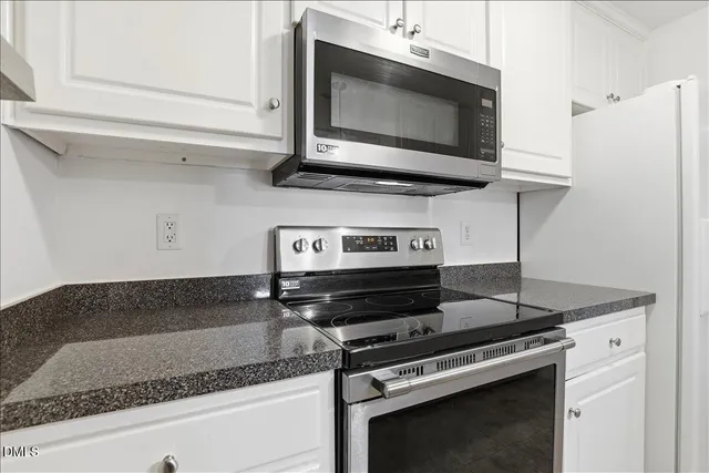 a kitchen with stainless steel appliances granite countertop a refrigerator a stove and a sink