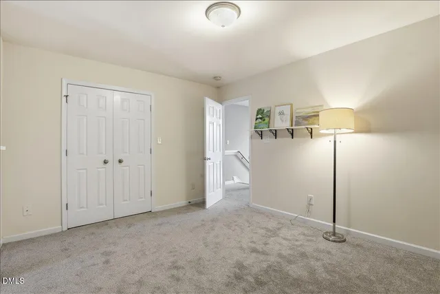 an empty room with chandelier fan and windows