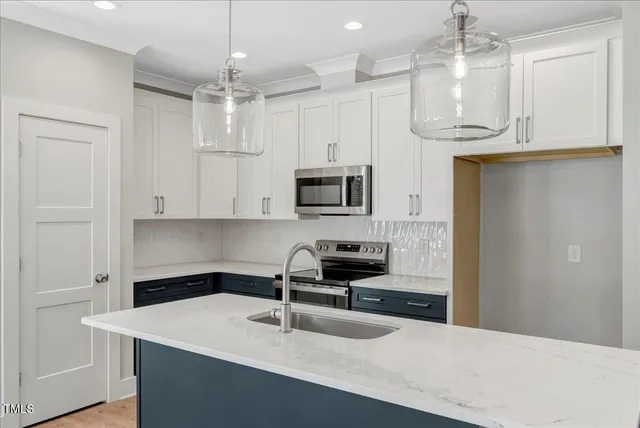 a kitchen with a sink a microwave a stove and refrigerator