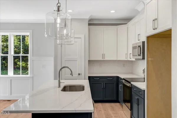 a kitchen with granite countertop a sink stainless steel appliances and cabinets