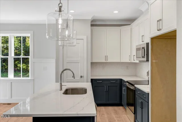 a kitchen with granite countertop a sink stainless steel appliances and cabinets