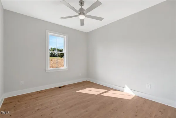 an empty room with a window and a fan