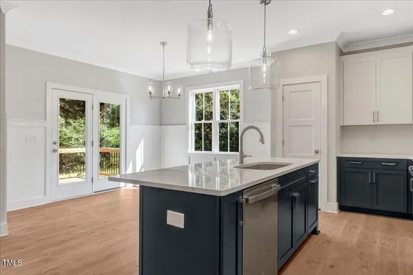 a kitchen with kitchen island granite countertop a stove a sink a center island and windows