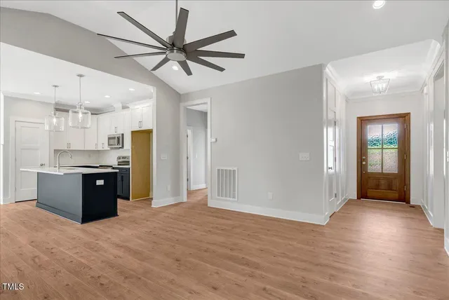 a large kitchen with stainless steel appliances kitchen island a chandelier