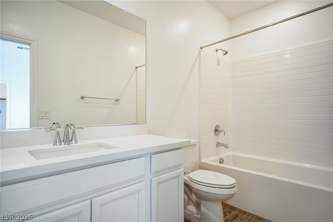 7348 North Decatur Boulevard, Unit 1 North Las Vegas, NV 89084 - Photo 11 of 17 Refined bathroom features a clean vanity, white subway tile shower, and wood-look flooring.