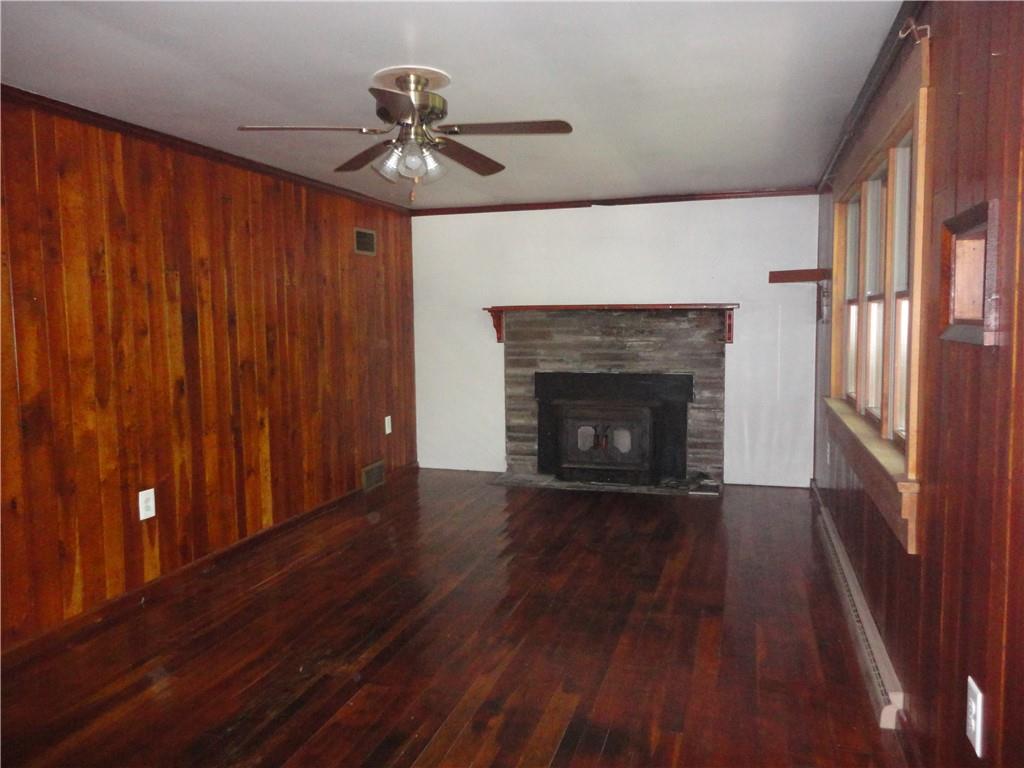3202 Listonburg Road Confluence, PA 15424 - Photo 4 of 26 a view of an empty room with wooden floor fireplace and a window