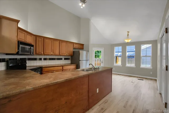 a kitchen with stainless steel appliances a sink a stove and cabinets