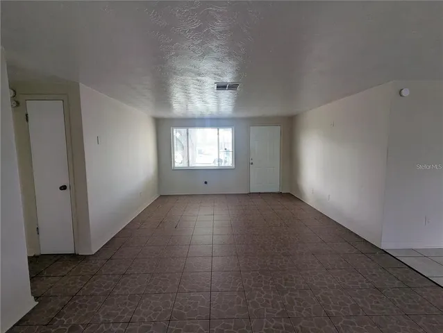 an empty room with windows and closet
