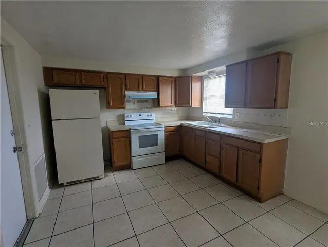 a kitchen with a white stove top oven and cabinets