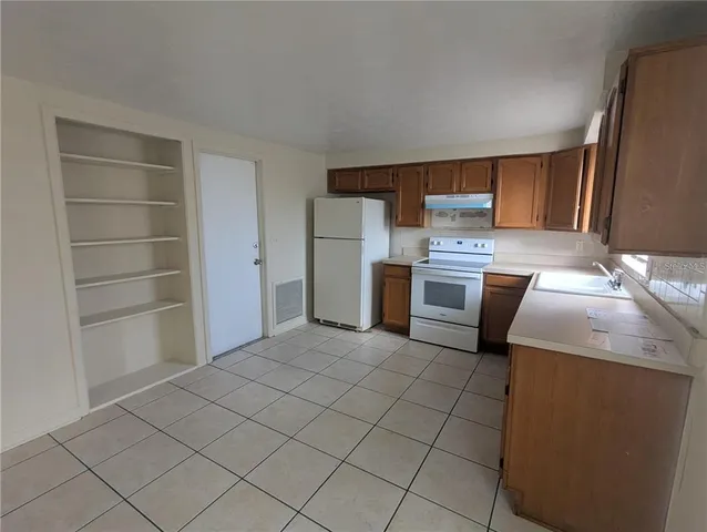 a kitchen with a sink a stove and cabinets