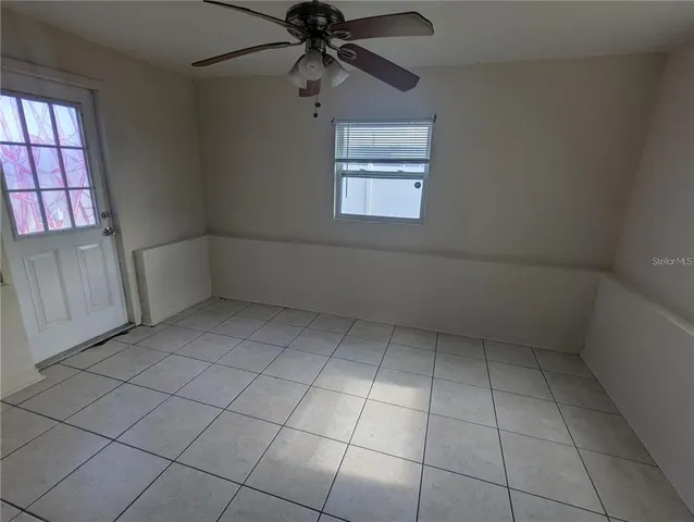 an empty room with windows and fan