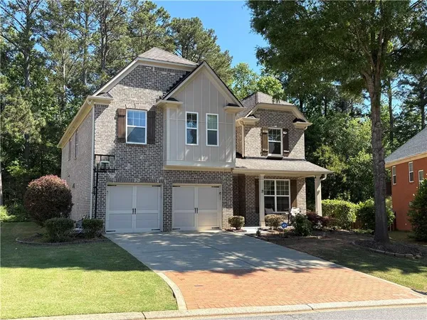 a front view of a house with yard and trees