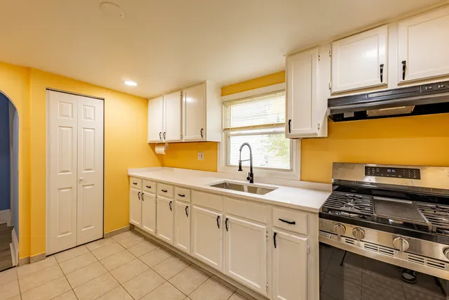 a kitchen with stainless steel appliances granite countertop a sink stove and cabinets