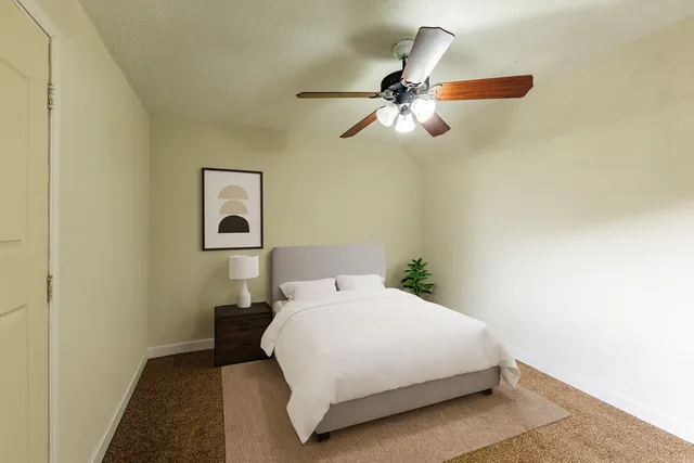 a bedroom with a bed and a painting on the wall