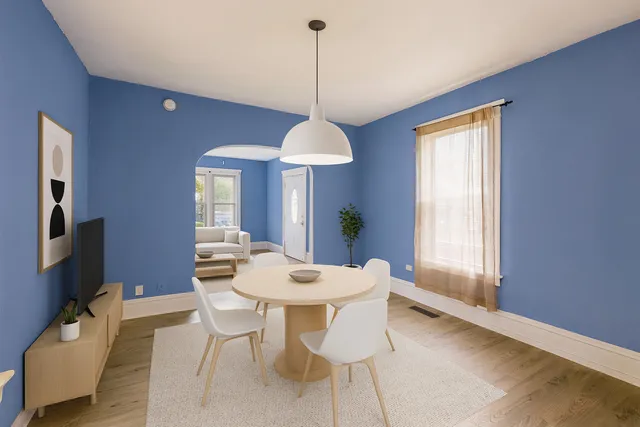 a dining room with furniture a chandelier and wooden floor