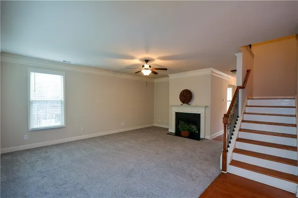 a view of an empty room with fireplace and wooden floor