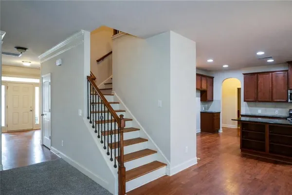 a view of a kitchen with kitchen island wooden floor and staircase