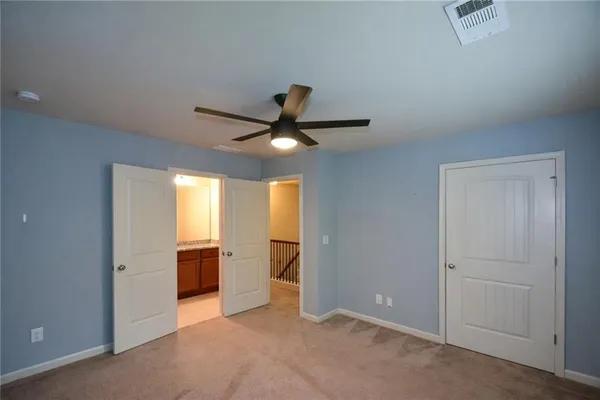an empty room with closet and windows