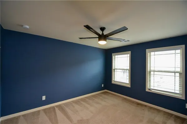 a view of a big room with windows and ceiling fan