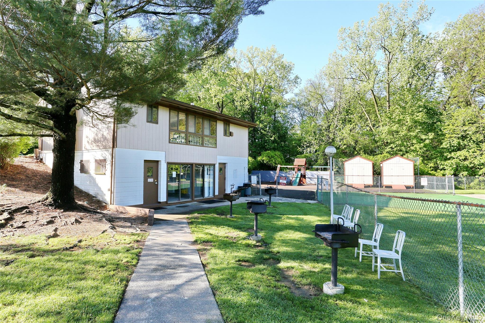 5 Secora Road, Unit F7 Spring Valley, NY 10977 - Photo 20 of 21 a front view of a house with garden and trees