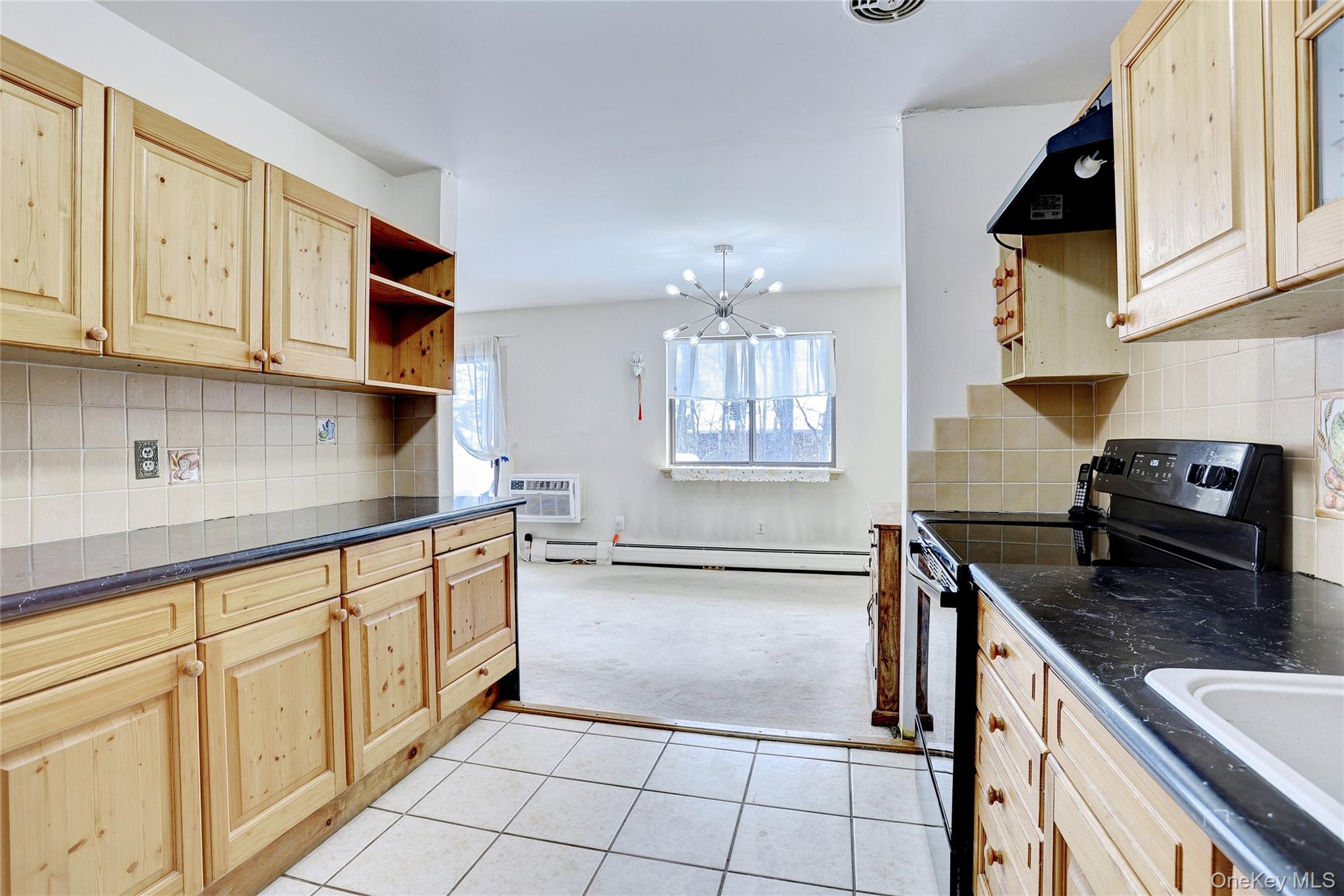 5 Secora Road, Unit F7 Spring Valley, NY 10977 - Photo 4 of 21 a kitchen with granite countertop a sink stove and cabinets