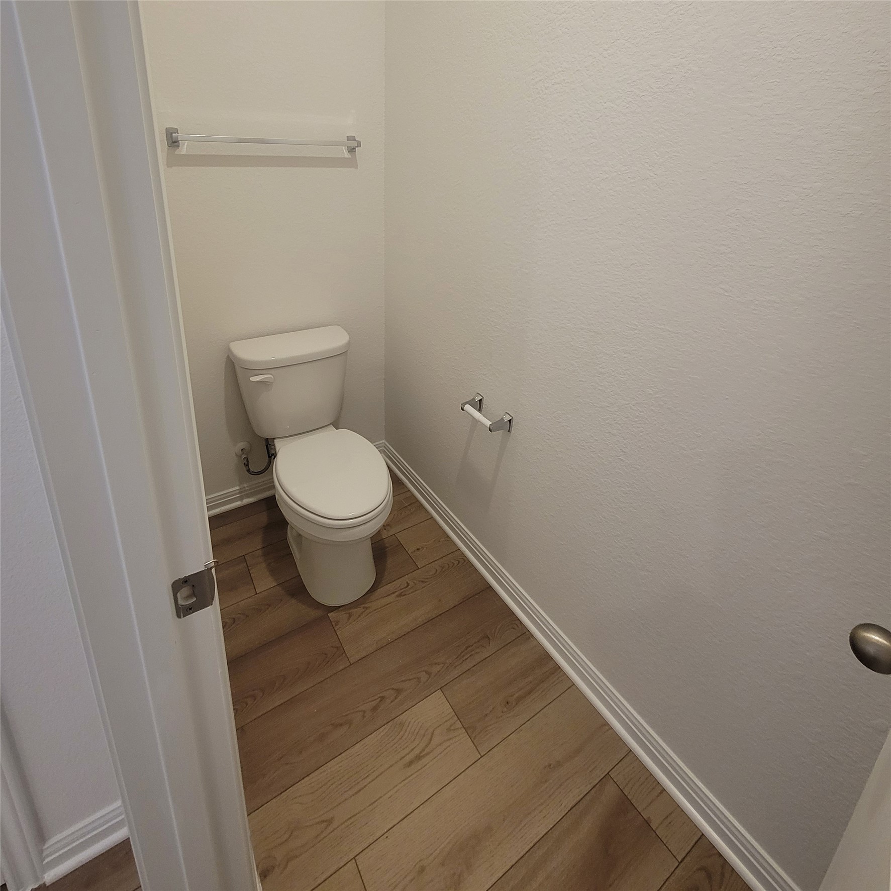 200 Callahan Loop Buda, TX 78610 - Photo 7 of 13 Powder room featuring a white toilet, wood-finish flooring, and white baseboards
