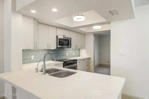 a kitchen with kitchen island a sink appliances and cabinets